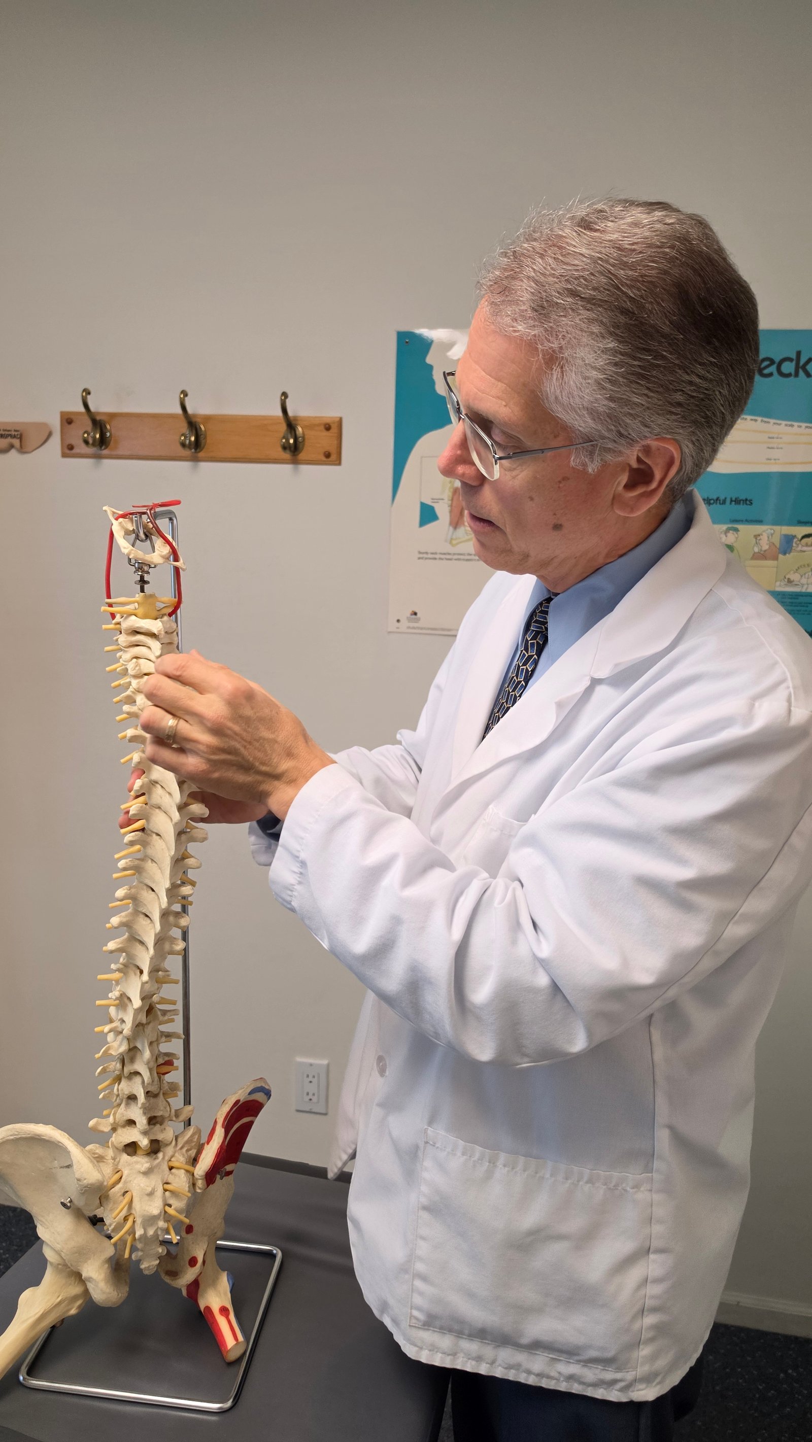 Dr. Brostowin explaining a model of the spine in his office